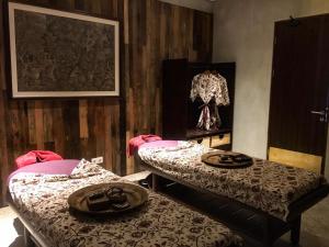 a room with two beds in a room with a picture at ARTOTEL Haniman Ubud in Ubud