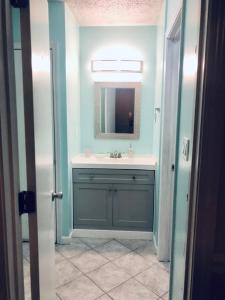 a bathroom with a sink and a mirror at Purple Sunset - Central Destin - 1BR Condo in Destin