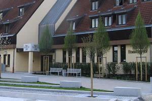 a building with two benches in front of it at Hotel Hembacher Hof in Rednitzhembach