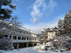 un bâtiment avec de la neige devant lui dans l'établissement Nikko Kanaya Hotel, à Nikkō