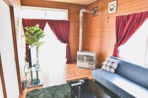 a living room with a blue couch and a tv at The Good Location house Hakodate in Hakodate