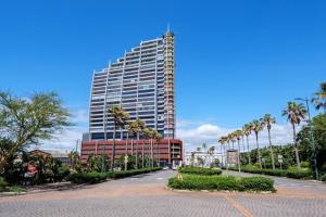 a tall building with palm trees in front of it at Executive apartment at Ushaka Marine in Durban