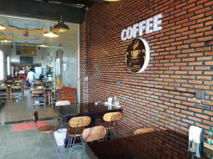 a brick wall with a table and chairs in a restaurant at Avocado Guesthouse in Senmonorom