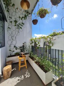 einen Innenhof mit Topfpflanzen und einem Holztisch in der Unterkunft Aki 秋 Hostel in Da Lat
