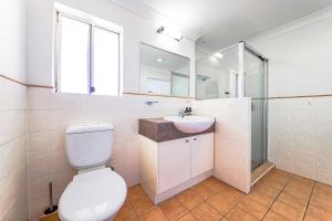 a bathroom with a toilet and a sink and a mirror at Calamvale Business or Holiday like Home in Brisbane