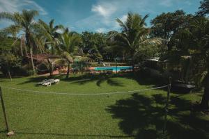 a resort with a swimming pool and palm trees at Pousada Chácara Rama in Botucatu