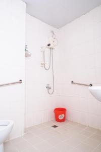 a bathroom with a shower and a red bucket at GETZ HOTEL MANILA in Manila