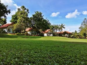 una casa en un campo de golf con un green en Vimannam Resort, en Phetchaburi