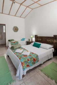 a bedroom with two beds in a room with green mats at Pousada Chácara Rama in Botucatu