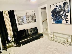 a living room with a black leather couch and a glass table at fearlessRose Vacation Rental in Springfield