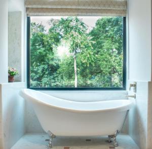 斋浦尔Brij Nest, Jaipur - An All Suite Boutique Hotel的带窗户的浴室里的浴缸