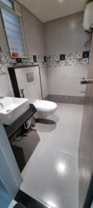 a bathroom with a toilet and a sink at Status Homeaway Service Apartments in Nashik +19 photos