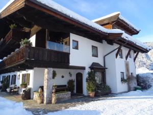 a house with a balcony in the snow at Landhaus Feller in Reith bei Kitzbühel