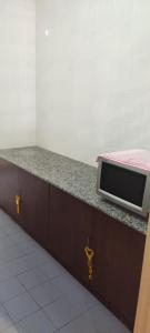 a counter top with a microwave on top of it at Condo D'Savoy A Famosa Resort Melaka Homestay in Kampong Pulau Sebang
