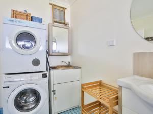 a laundry room with a washing machine and a sink at Roskell Retreat Pet Friendly 5 Mins Walk to Beach in Callala Beach