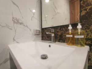 een wastafel met twee flessen zeep erop bij Super 1BDR in Water Park Resort in Pattaya South +13 foto's