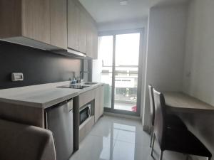 een kleine keuken met een wastafel en een vaatwasser bij Super 1BDR in Water Park Resort in Pattaya South