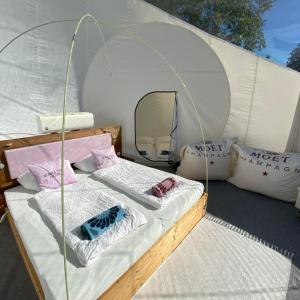 a bed in a tent with pillows on it at Bubble Tent Hotel in Weyregg