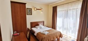 a hotel room with a bed and a window at Pensiunea Nimbus in Arad