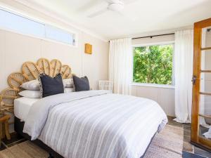 - une chambre avec un grand lit et une grande fenêtre dans l'établissement Boho Pet Friendly 1 Min Walk to Beach, à Culburra Beach