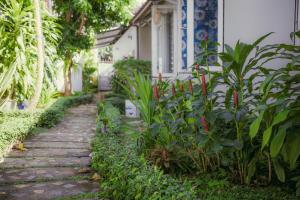 un chemin en pierre devant une maison avec des plantes dans l'établissement Manh Duyen Garden Homestay, à Duong Dong