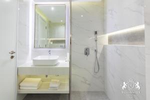 Baño blanco con lavabo y espejo en Westminster Burj Al Nujoom en Dubái