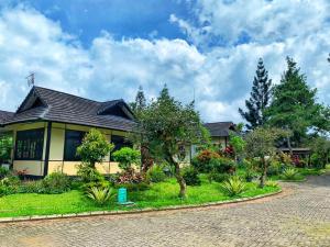 a house with a cobblestone driveway at Designer Villa Osaka in Puncak