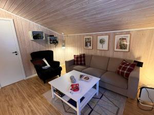 een woonkamer met een bank en een tafel bij Vennebo - Koselig liten hytte med alle fasiliteter in Al