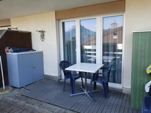 a table and chairs on a balcony with a window at Elfe-Apartments Studio Apartment for 2 guests in Emmetten