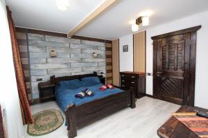 a bedroom with a blue bed and a wooden wall at Nord Cottage in Yablunytsya