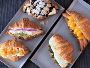 a group of sandwiches and croissants on plates at LAMP LIGHT BOOKS HOTEL fukuoka in Fukuoka