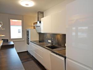 a kitchen with white cabinets and a sink at Ferienwohnung Donaublick in Tulln