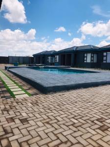 a swimming pool in front of a house at RMB Luxury Lodge in Ga-Mothiba