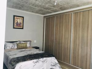 a bedroom with a bed and a large sliding glass door at RMB Luxury Lodge in Ga-Mothiba +8 photos