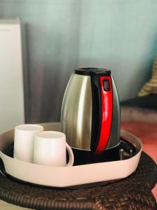 a coffee pot and cups on a tray on a table at RMB Luxury Lodge in Ga-Mothiba