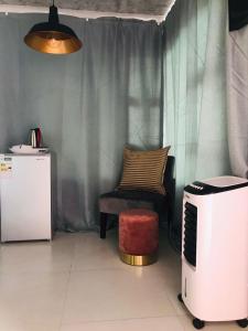 a living room with a chair and a microwave at RMB Luxury Lodge in Ga-Mothiba