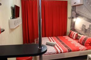 1 dormitorio con 1 cama con cortina roja en Современная smart квартира для 3-их. чел. М.Академика Павлова , р-к Барабашова, en Járkov