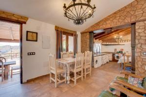 a kitchen and dining room with a table and chairs at Casa Miramar in Almogía