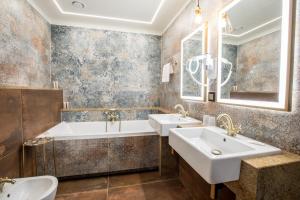 
a bathroom with a tub, sink, mirror and bathtub at Hotel Diament Plaza Katowice in Katowice
