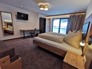 Schlafzimmer mit einem Bett, einem Schreibtisch und einem Fenster in der Unterkunft Apart Grafspitz in Ischgl