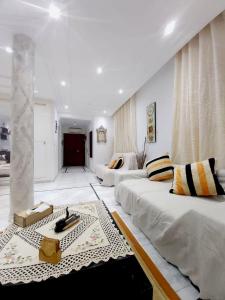 a large living room with two beds and a rug at Ideal Appart Sidi Bou Said in Sidi Bou Saïd