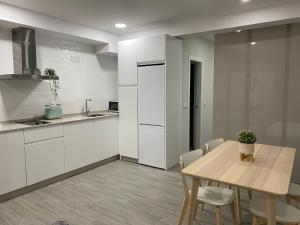 a kitchen with white cabinets and a table and chairs at Loft céntrico 1 Córdoba in Córdoba