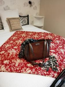 a brown purse sitting on top of a bed at Chambre d'hôtes LE PUITS DARCY in Montceau-les-Mines