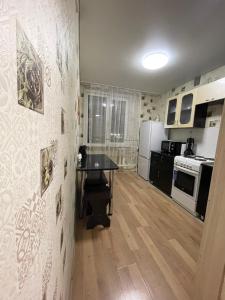 eine Küche mit einem Tisch in der Mitte eines Zimmers in der Unterkunft Apartment on Krasina-Abay street in Öskemen