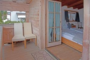Zimmer mit einem Fenster und einem Stuhl auf einer Veranda in der Unterkunft Egger Studio Hornblick in Reith bei Kitzbühel
