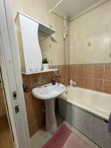 ein Badezimmer mit einem Waschbecken und einer Badewanne in der Unterkunft Apartment on Krasina-Abay street in Öskemen