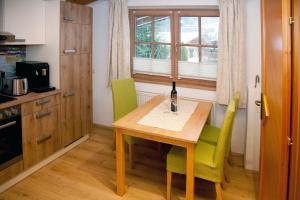 eine Küche mit einem Holztisch und grünen Stühlen in der Unterkunft Egger Studio Hornblick in Reith bei Kitzbühel