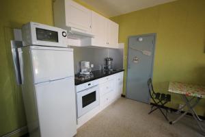 una cucina con frigorifero bianco e forno a microonde di 80m de la plage Appartement au rdc d'une maison 1 chambre 4 couchages cour LXRV9A a Portiragnes