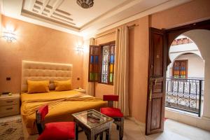 a bedroom with a bed and a table and a window at Riad Aymane in Marrakesh