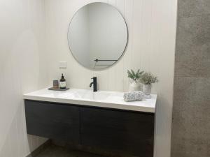 a bathroom with a white sink and a mirror at Kiama Palms on Terralong in Kiama +11 photos